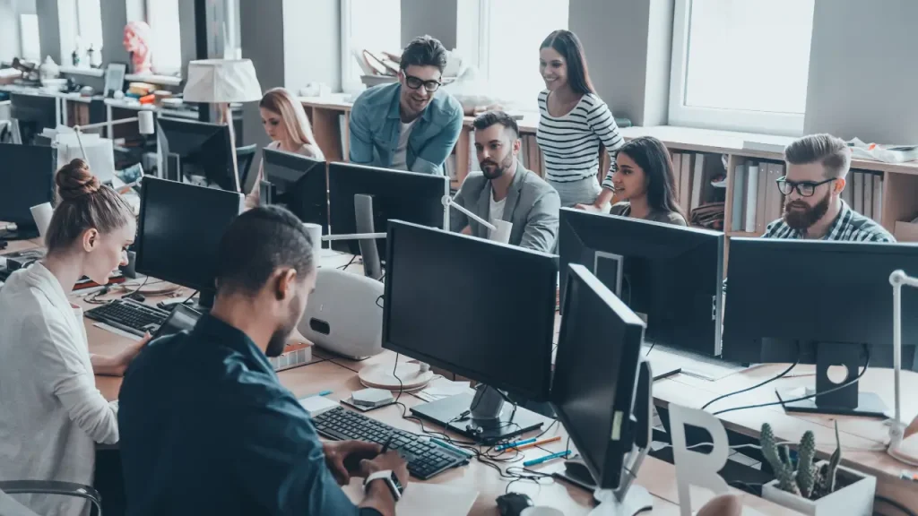 Equipe no trabalho em frente a computadores com inteligência emocional no trabalho