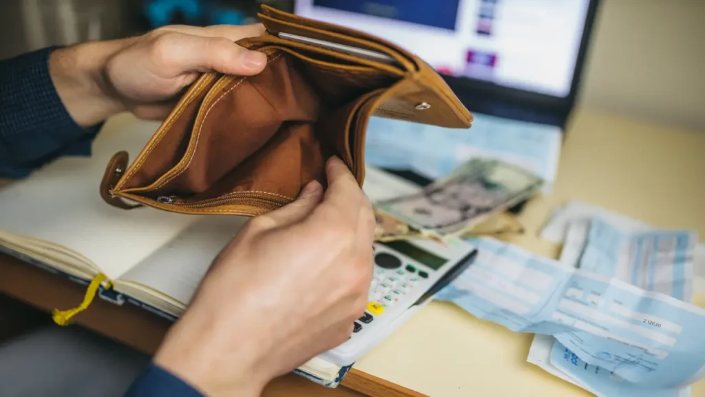 Homem abrindo carteira simulando como organizar sua vida financeira
